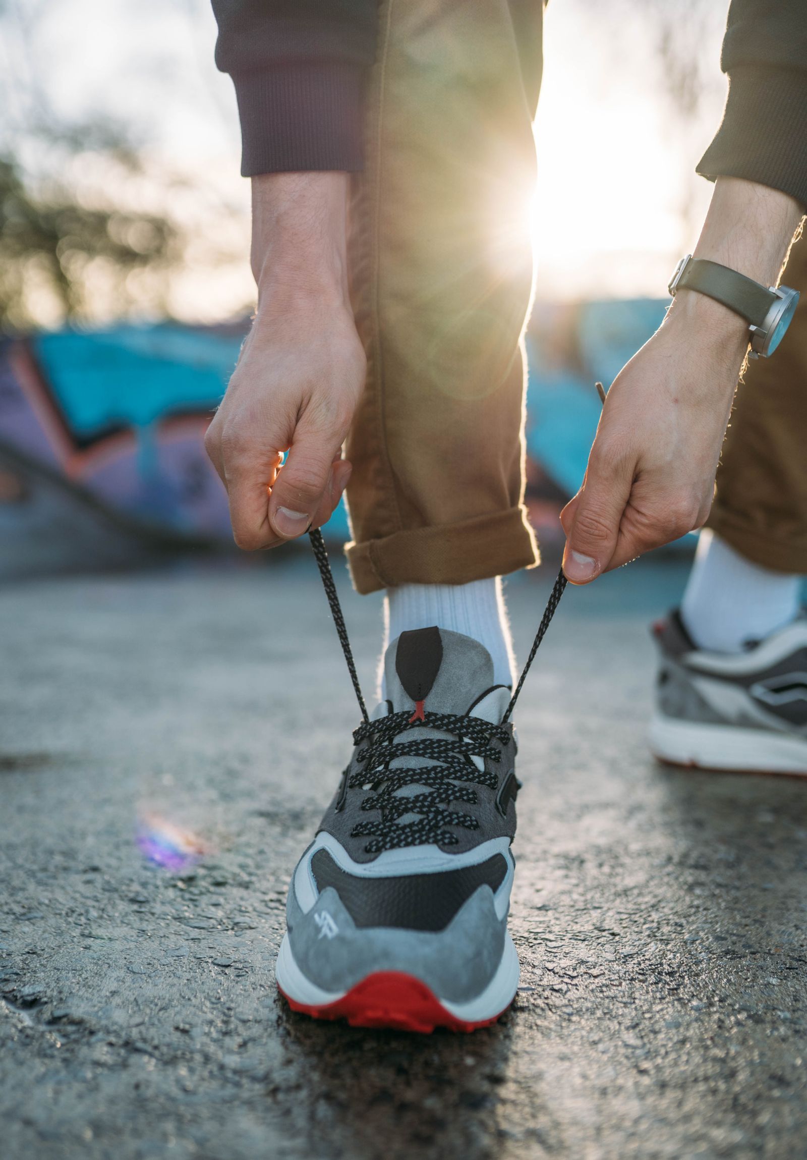 Une personne attache ses chaussures de course dans la lumière du matin.