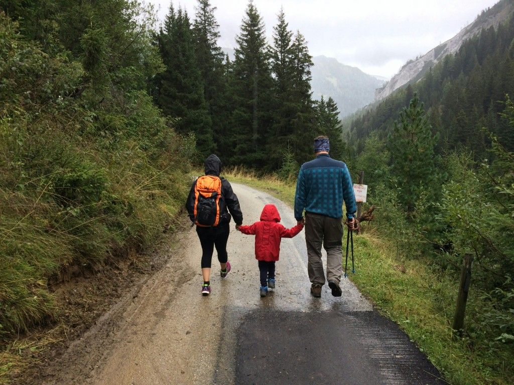 Une famille marche ensemble sur un sentier de montagne.